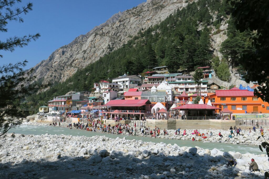 Busy village scene with colorful buildings by a mountainous riverside.